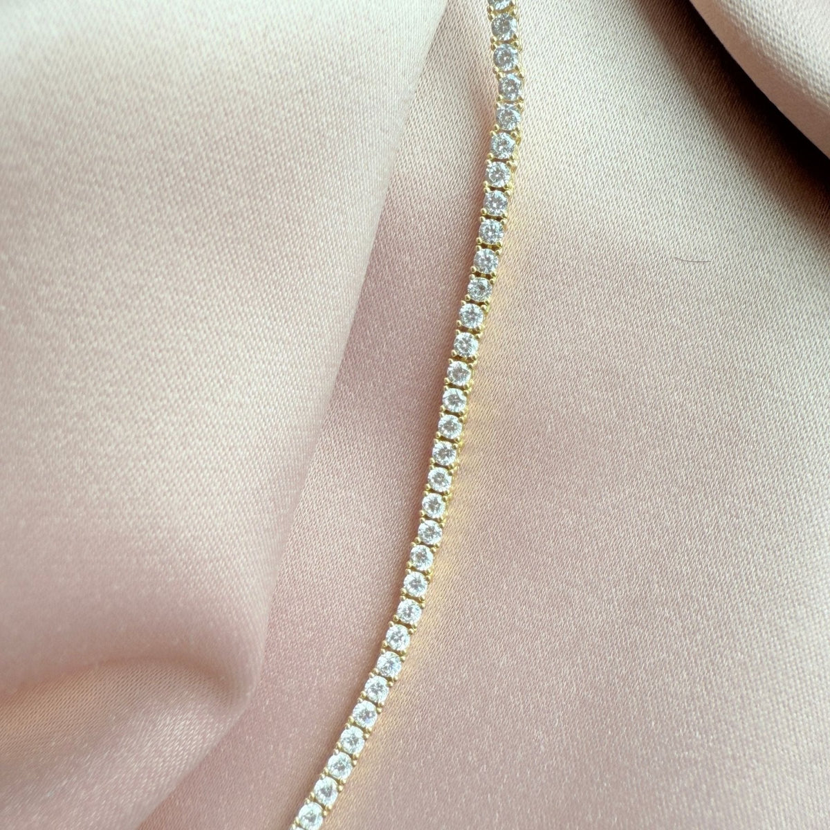 Close up of a tennis necklace with 2.5mm prong set cubic zirconia in gold plated sterling silver extreme by Camille Jewelry
close up