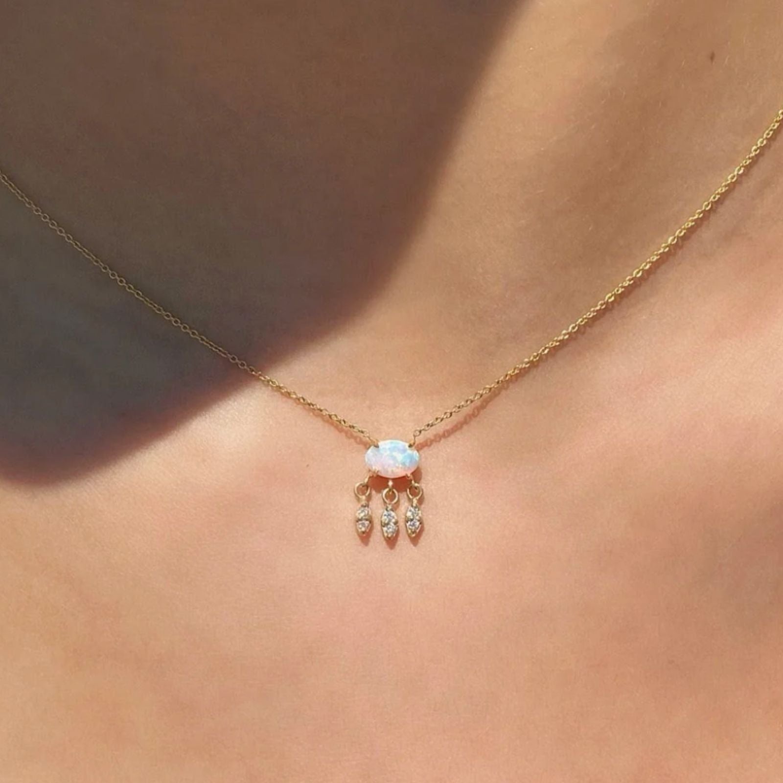 Oval opal necklace with three marquise diamond charms on model neck | Camille Jewelry
