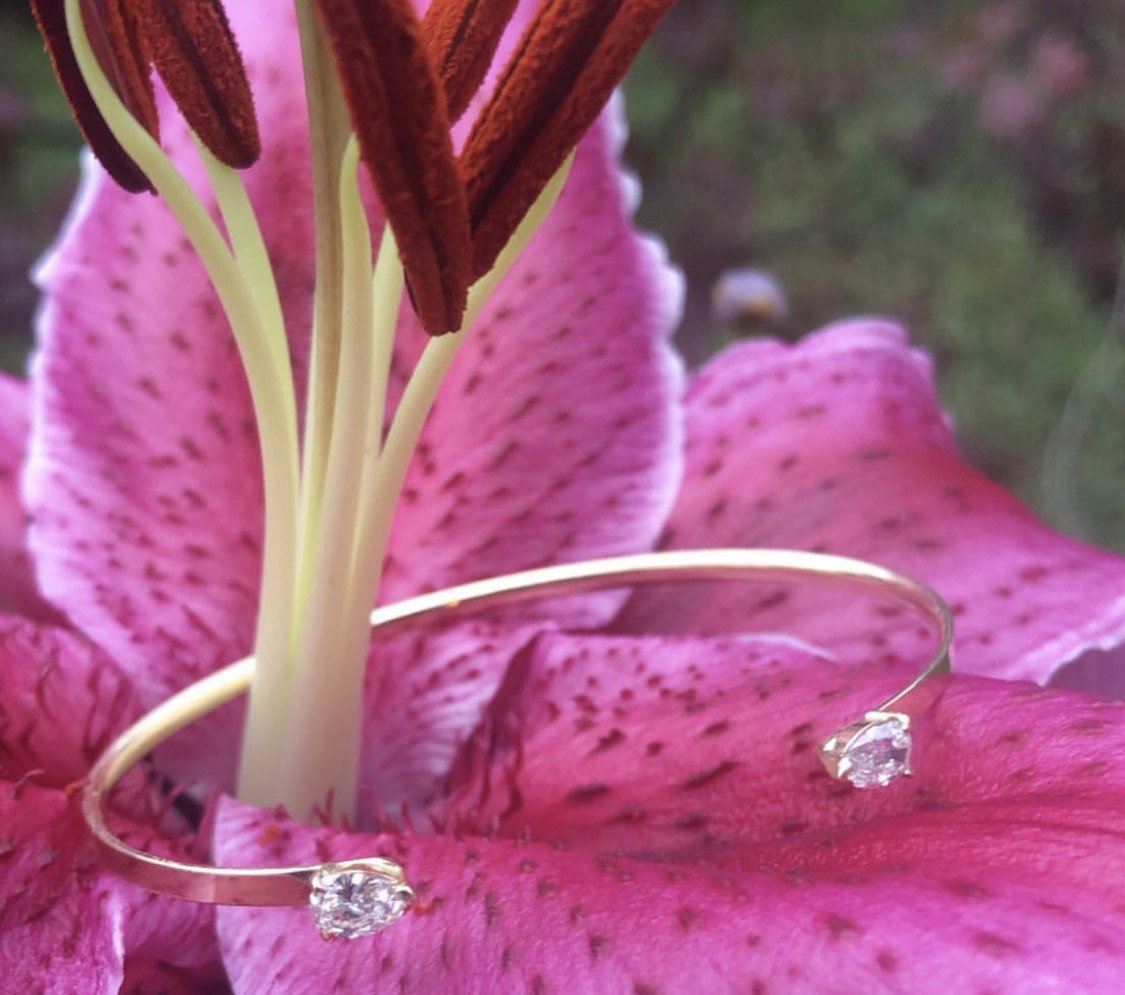 Open Cuff Bracelet | Pear-Shaped Diamond Bangle in 14K Yellow Gold on flower display - Camille Jewelry