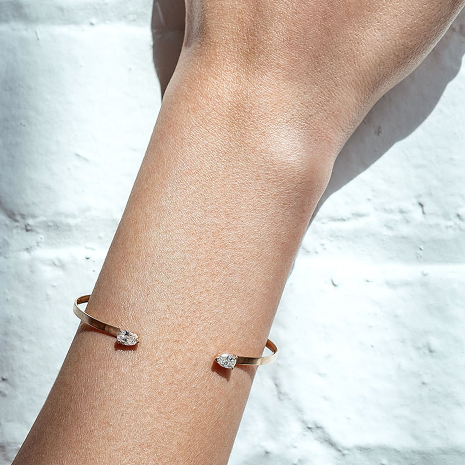 Open Cuff Bracelet | Pear-Shaped Diamond Bangle in 14K Yellow Gold on models arm- Camille Jewelry