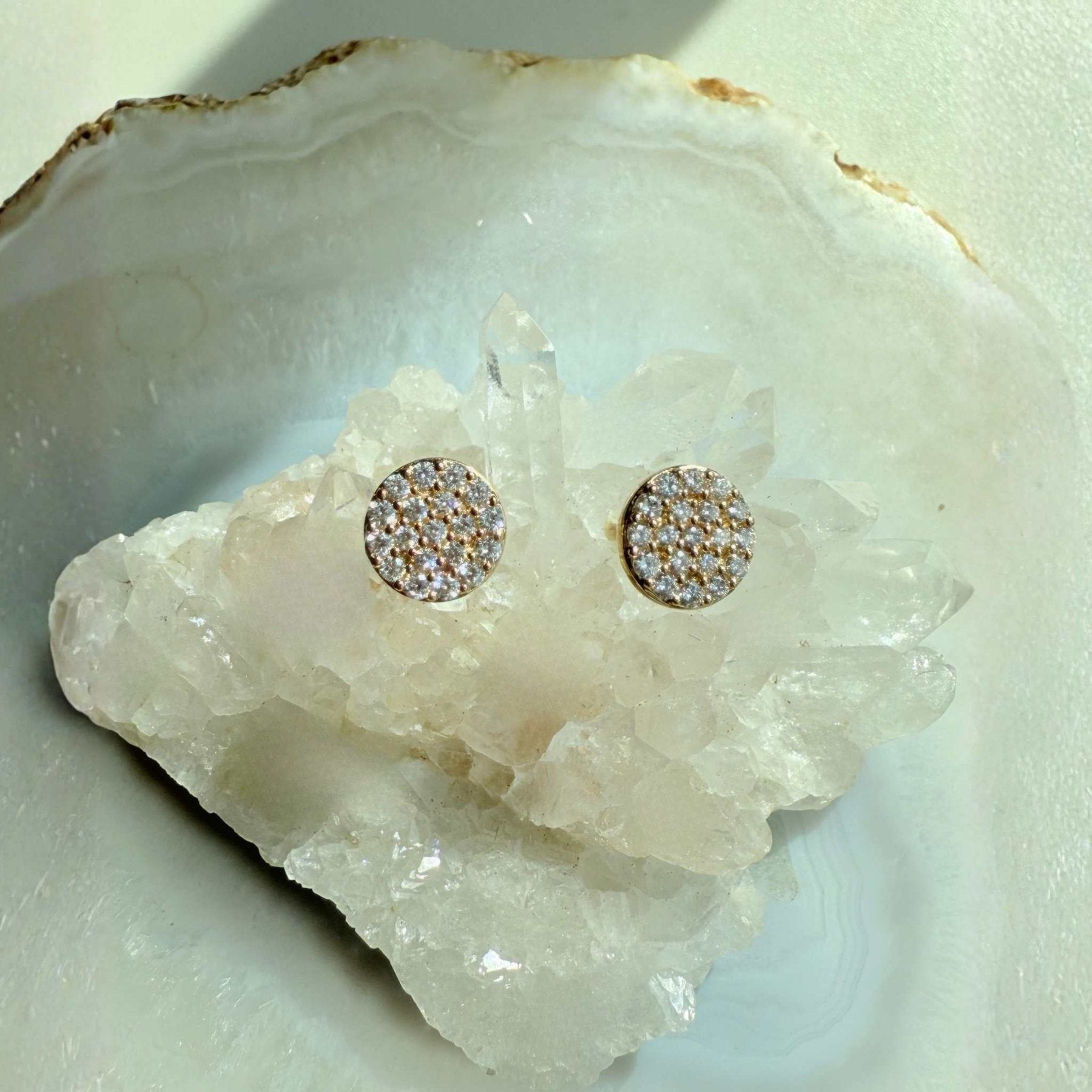 Pavé Diamond Stud Earrings in 14k yellow gold on a quartz display by Camille Jewelry