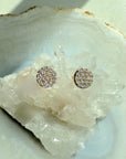 Pavé Diamond Stud Earrings in 14k yellow gold on a quartz display by Camille Jewelry