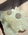 Pavé Diamond Stud Earrings in 14K yellow gold on a quartz display by Camille Jewelry