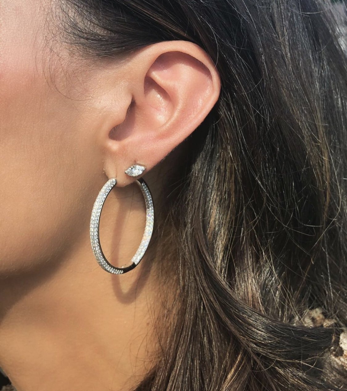Woman wearing pavé hinged hoop earrings in 14K gold plated sterling silver by Camille Jewelry