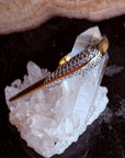 Camille Jewelry Phoenix Collection crossover ring on a crystal with dark background
