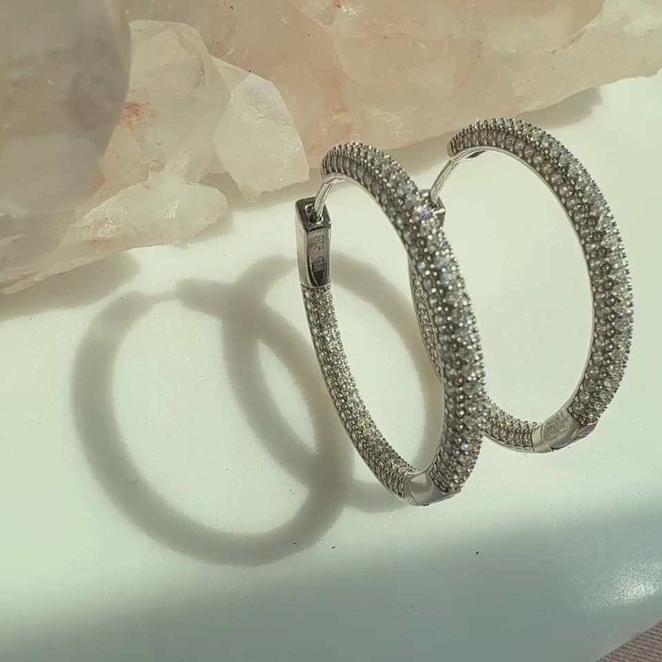 Sterling silver pave hinged hoop earrings on a soft white background by Camille Jewelry.