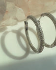 Sterling silver pave hinged hoop earrings on a soft white background by Camille Jewelry.