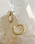 14k yellow gold hinged diamond hoop earrings on quartz display| Camille Jewelry 