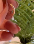 Hand modeling a diamond dangle off of a hinged hoop earring. | camille Jewelry
