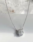 Solitaire diamond necklace with halo on a delicate chain in white gold. Rotating product style on a quartz stone | Camille Jewelry