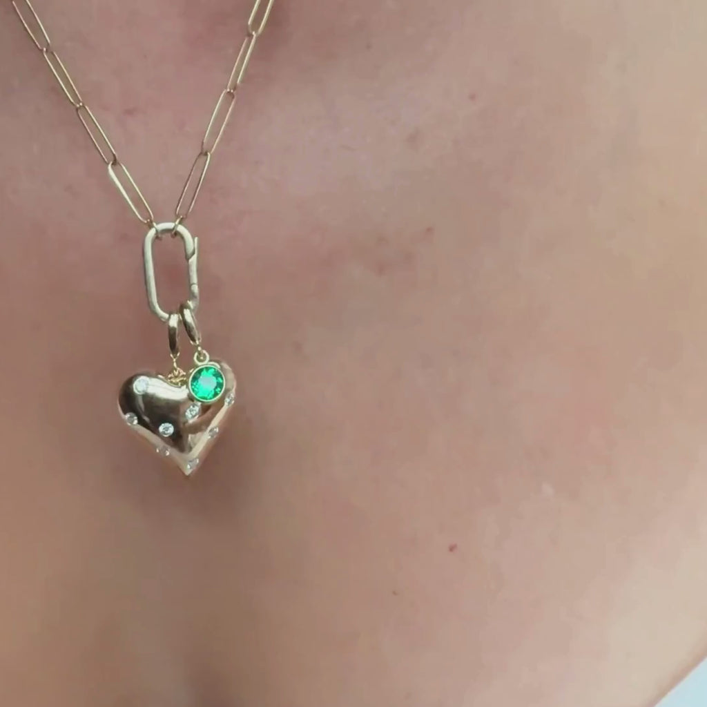 14K yellow gold puffy heart charm and emerald bezel set charm on a charm holder necklace by Camille Jewelry.