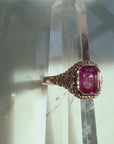 pink sapphire ring in natural diamonds in 14k rose gold on a quartz display by Camille Jewelry.
