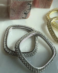 video of pave square rings in rhodium plated and gold plated sterling silver on a quartz display for Camille Jewelry