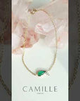 Video of pear-shaped emerald and diamond bracelet in 14K gold by Camille Jewelry, showing dainty fine-jewelry sparkle and movement for layering or gifting.