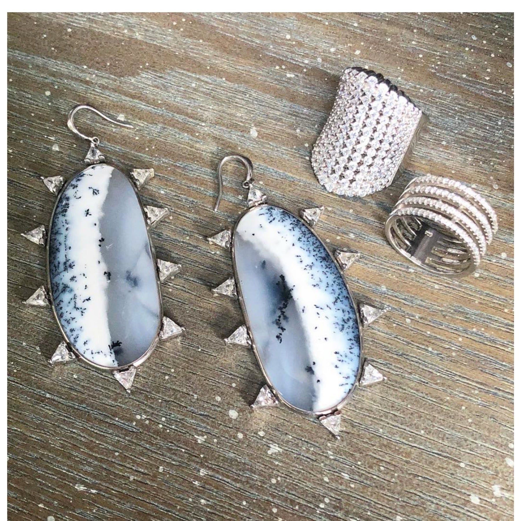 Silver Simulated Diamond Cocktail Ring on display with statement earrings and other silver jewelry- Camille Jewelry