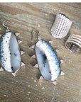Silver Simulated Diamond Cocktail Ring on display with statement earrings and other silver jewelry- Camille Jewelry