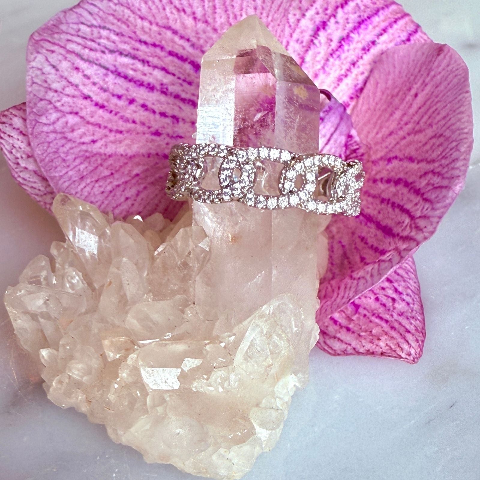 Silver Pave Curb Chain Ring on a quartz display and pink orchid flower background byCamille Jewelry
