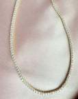 Close up of a tennis necklace with 2.5mm prong set cubic zirconia in gold plated sterling silver by Camille Jewelry
satin cloth
