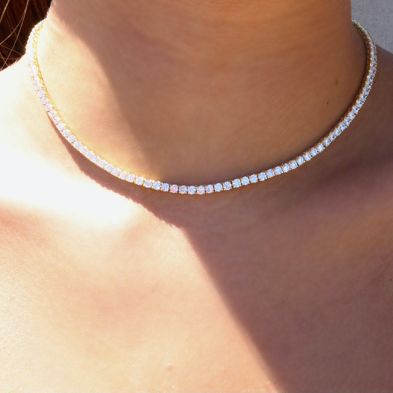 Woman wearing a modern tennis necklace in gold plated sterling silver by Camille Jewelry