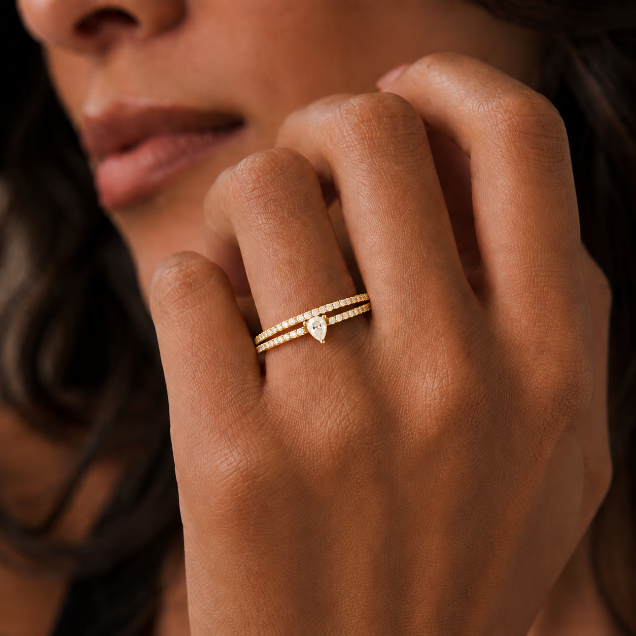Woman wearing a skinny trillion pavé stacking ring in 18K gold vermeil on her hand by Camille Jewelry