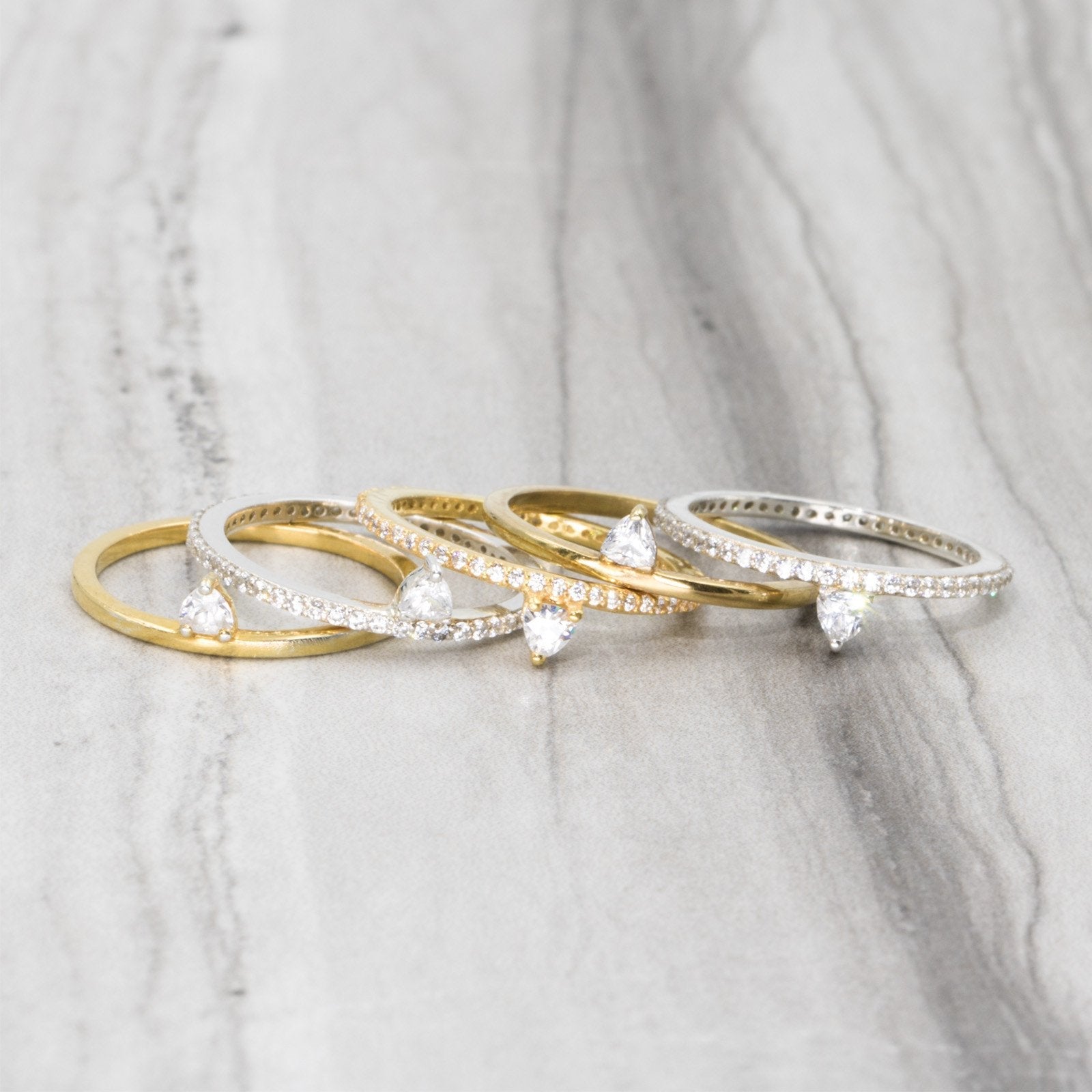 Stack view of a skinny trillion pavé stacking ring in sterling silver amd 18k Gold Vermeil laying by Camille Jewelry