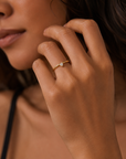 Skinny trillion ring in 18K gold vermeil with a cubic zirconia stone on a model by Camille Jewelry