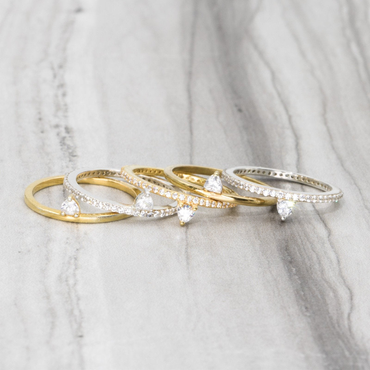 Skinny Trillion Ring – Dainty Women’s Jewelry in Gold Vermeil &amp; silver on a marble display- Camille Jewelry