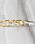 Skinny Trillion Ring – Dainty Women’s Jewelry in Gold Vermeil & silver on a marble display- Camille Jewelry