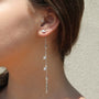 Sterling silver dangle charm earrings with trillions on a model -- Camille Jewelry