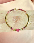 Tourmaline bracelet in 14K gold filled with graduated watermelon tourmaline rondelles and a smooth pink tourmaline center bead on a white background by Camille Jewelry